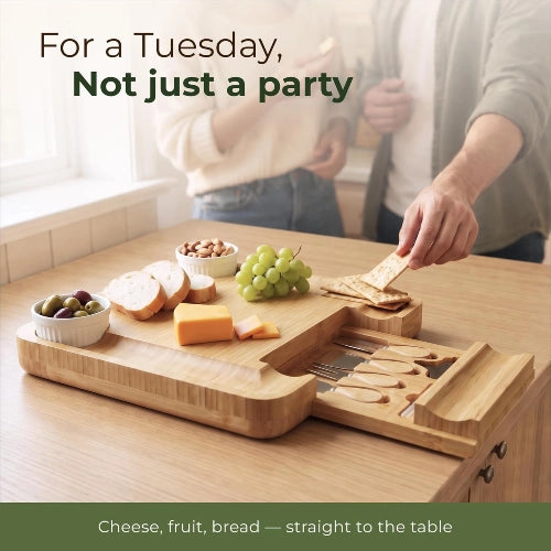 Couple enjoying casual wine and cheese appetizers on a square bamboo charcuterie board with extended cutlery drawer on a bright kitchen island.