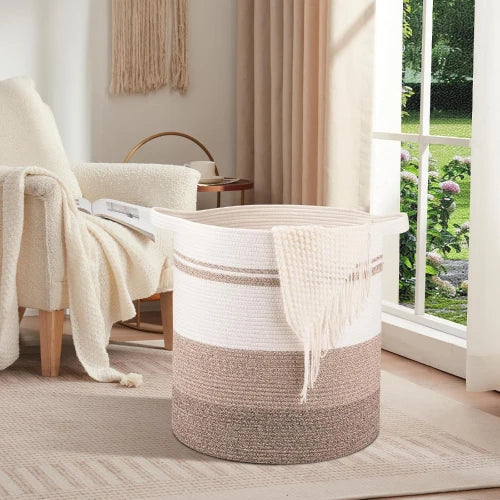 Extra large 120L round woven cotton rope laundry hamper in cozy bedroom by armchair with throw blanket
