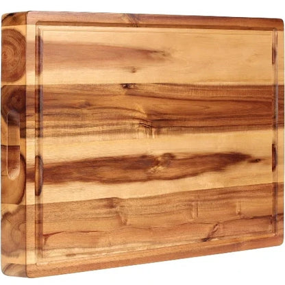 Large acacia wood edge-grain butcher block cutting board with perimeter juice groove and carved side handle