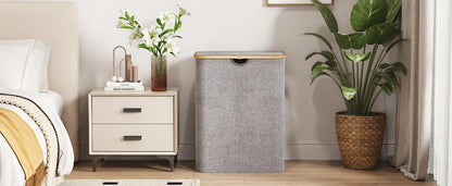 120L foldable laundry hamper with lid and bamboo handles placed beside nightstand in a modern bedroom