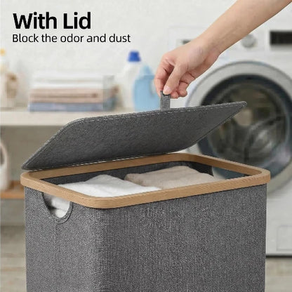 Close-up of hand lifting the hinged fabric lid of a gray slim laundry hamper with natural bamboo frame to contain odors and dust