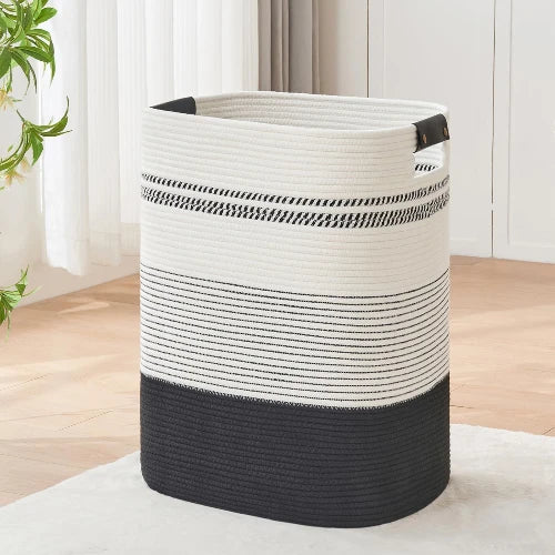 Tall rectangular woven cotton rope laundry hamper in black and white stripes with handles, standing upright on a rug.