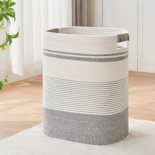 Tall rectangular woven cotton rope laundry hamper in charcoal gray and white mixed weave with durable handles, standing on a rug.